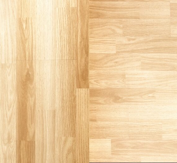 Side-by-side comparison of real hardwood flooring planks and luxury vinyl plank with similar wood-grain pattern.