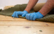 Man removing carpet underlay from a wooden floor.Home improvement project concept