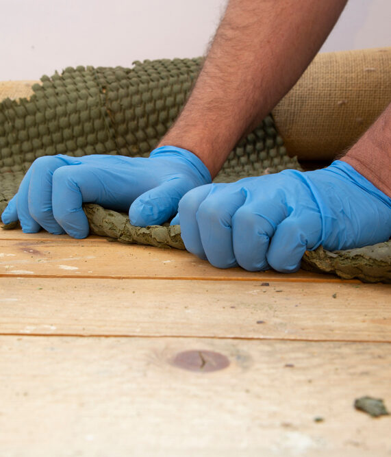 Man removing carpet underlay from a wooden floor.Home improvement project concept